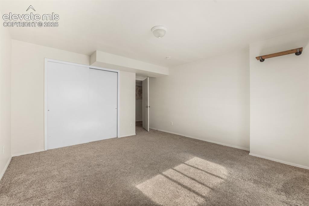 Image 27 of 37: Spacious room featuring neutral carpeting, light-toned walls, and a ceiling