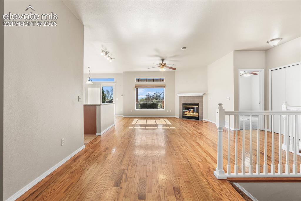 Image 4 of 37: Spacious living area featuring wood-finish flooring and a tile-surround fir
