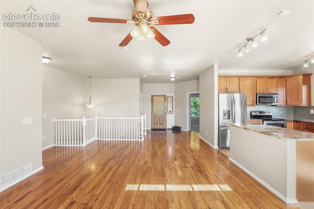 Image 9 of 37: Open-concept living space featuring wood-finish flooring, a ceiling fan wit