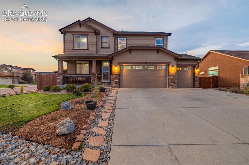Image 1 of 49: Two-story residence featuring a covered front porch with stone accents, a t