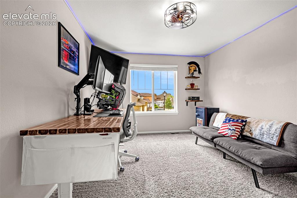 Image 23 of 49: Carpeted room featuring a window with natural light, a wood-finish desktop,