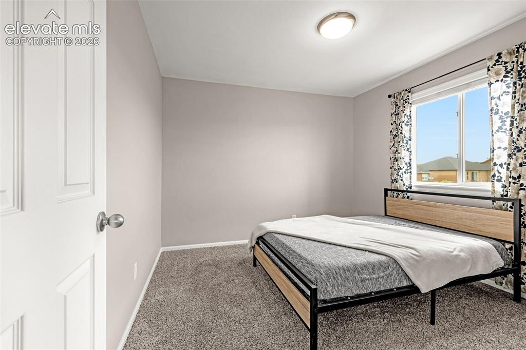 Image 25 of 49: Carpeted room with a modern ceiling light fixture, neutral wall finishes, a