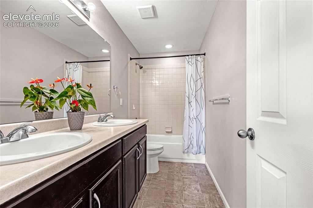 Image 26 of 49: Bathroom featuring a dual vanity with integrated sinks and chrome fixtures,