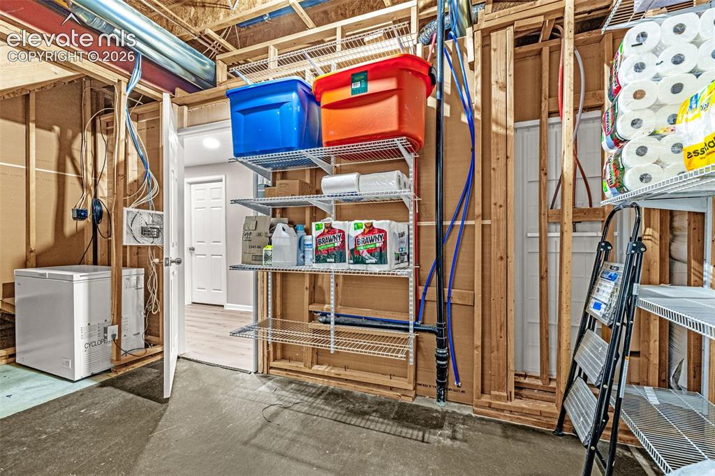 Image 33 of 49: Extra storage room in the basement with numerous shelves