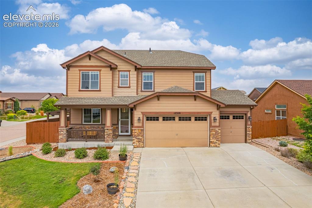 Image 42 of 49: Two-story residence featuring a covered front porch with stone accents, a t