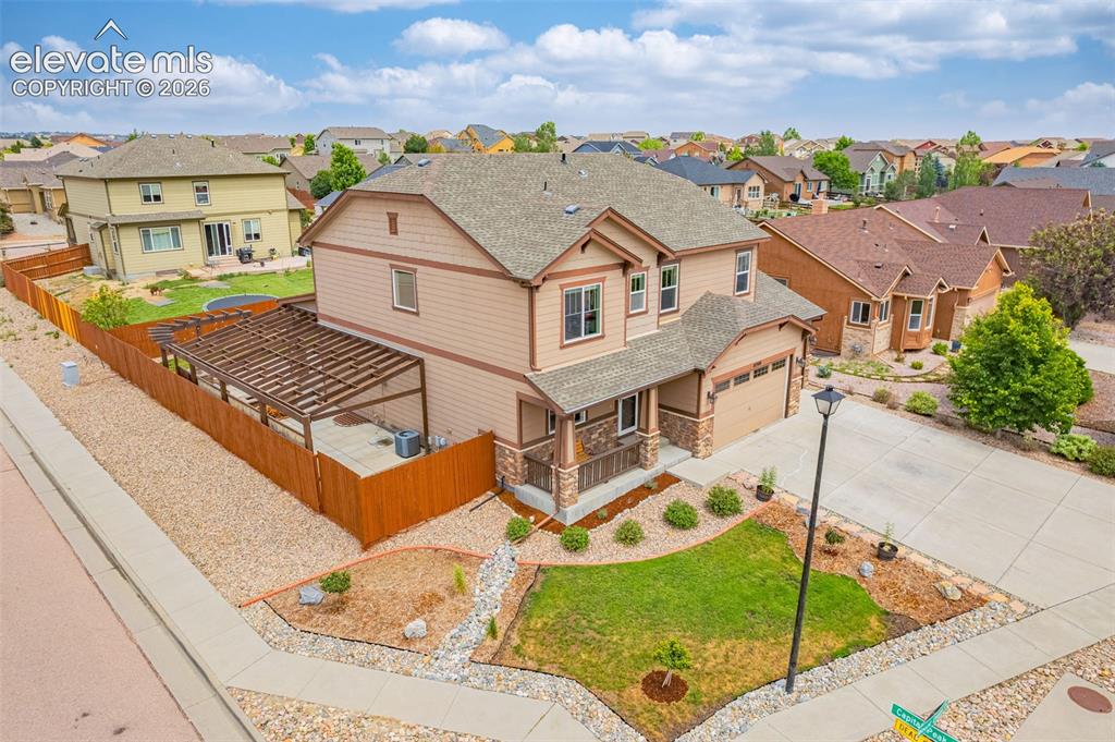 Image 43 of 49: Two-story residence featuring a two-car garage, stone accents, and a covere
