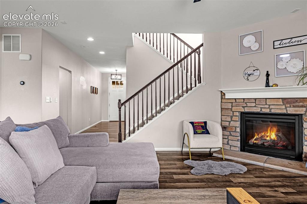 Image 6 of 49: Living area featuring a stone fireplace with a substantial mantel, luxury v
