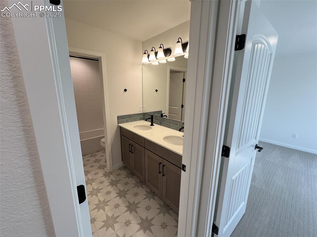 Image 13 of 17: Full bathroom featuring double vanity and shower / tub combination