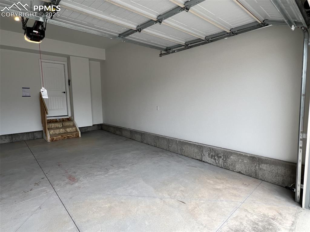 Image 16 of 17: Garage featuring a garage door opener
