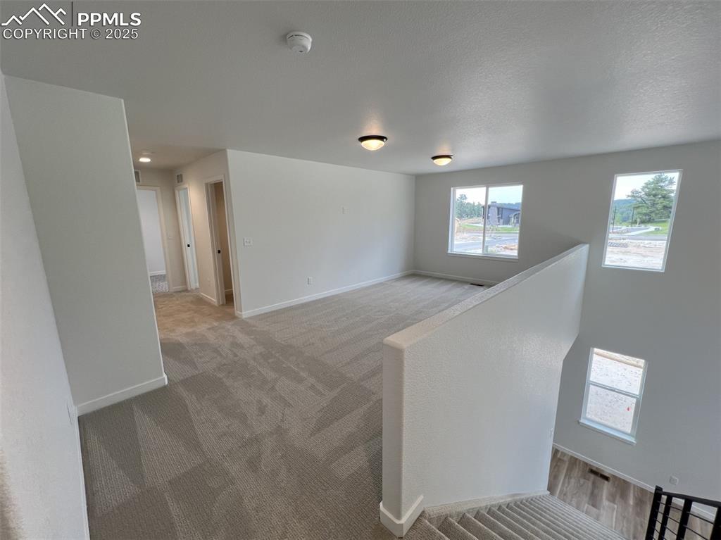 Image 7 of 17: Loft featuring plenty of natural light and light colored carpet