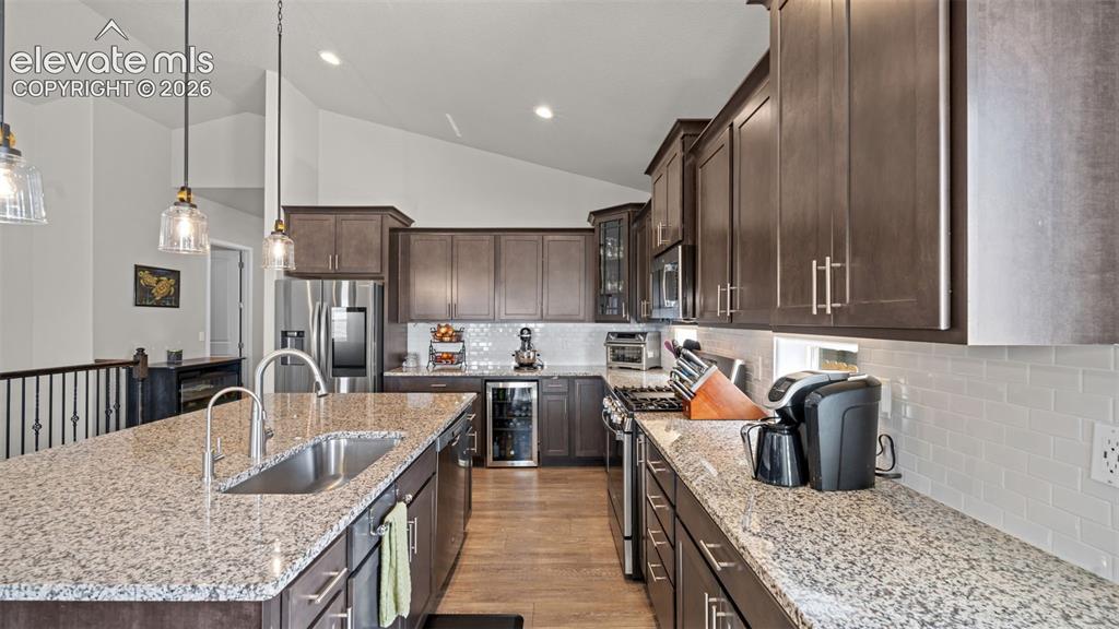 Image 10 of 39: Kitchen featuring a large island with an undermount sink, granite counterto