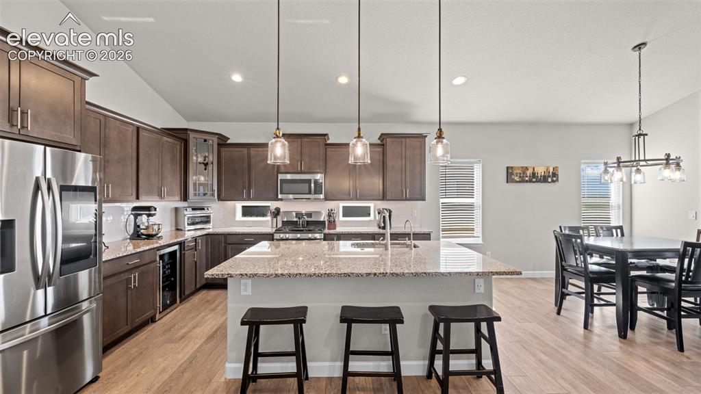 Image 11 of 39: Contemporary kitchen featuring wood-finish flooring and extensive cabinetry