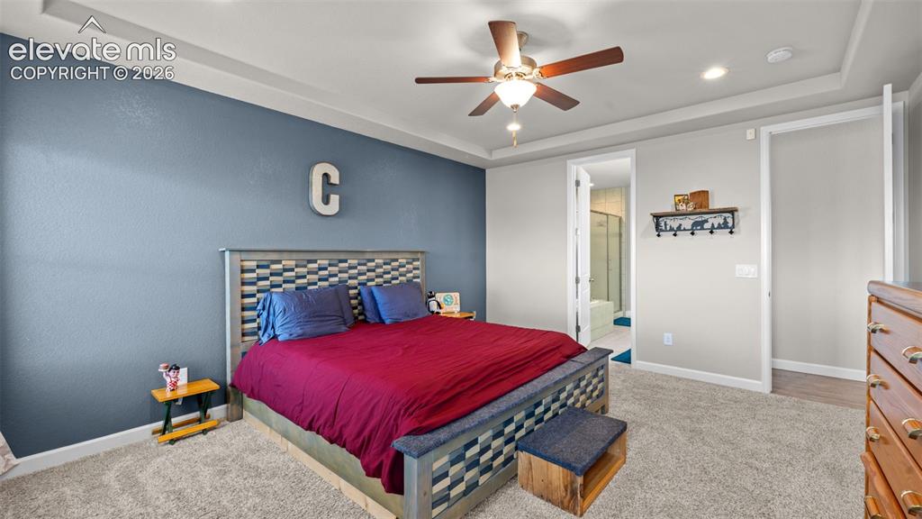Image 17 of 39: Spacious room featuring tray ceilings, a ceiling fan with integrated lighti