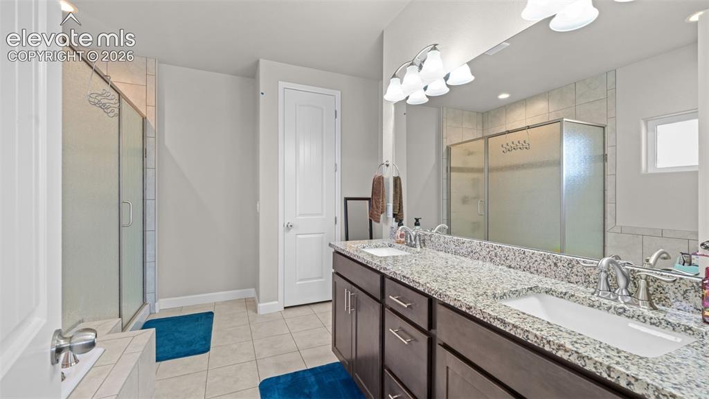Image 18 of 39: Dual vanity with granite-style countertops and integrated sinks