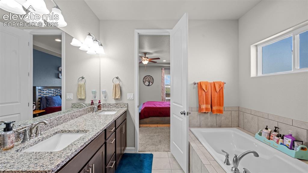 Image 19 of 39: Bathroom featuring a double vanity with granite countertop, dual undermount