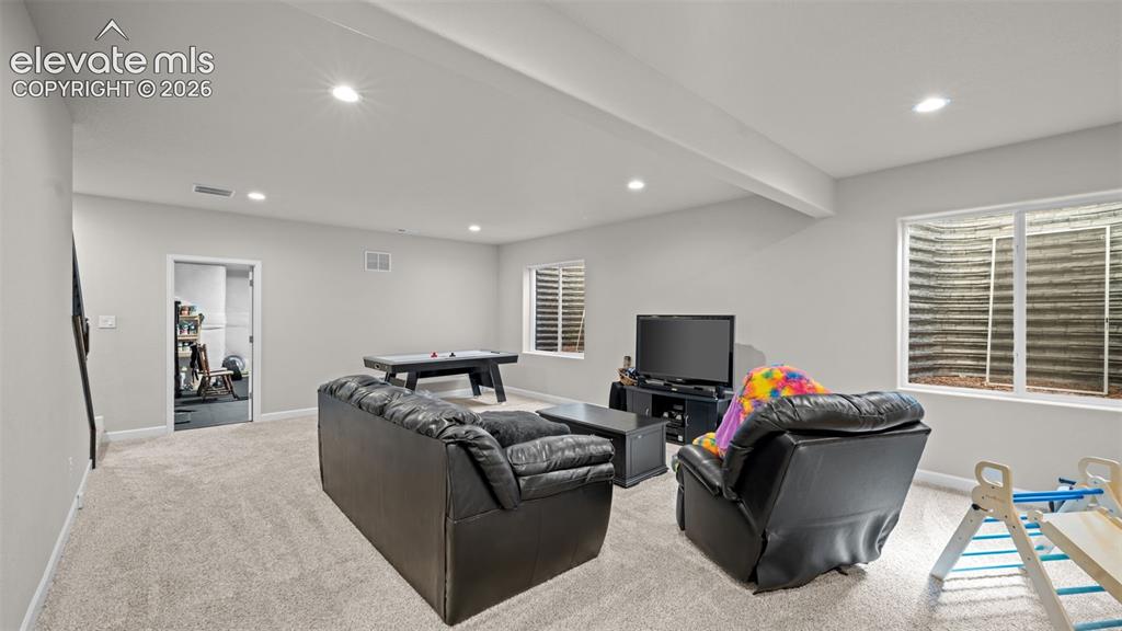 Image 25 of 39: Spacious entertainment area featuring light gray wall paint and recessed li