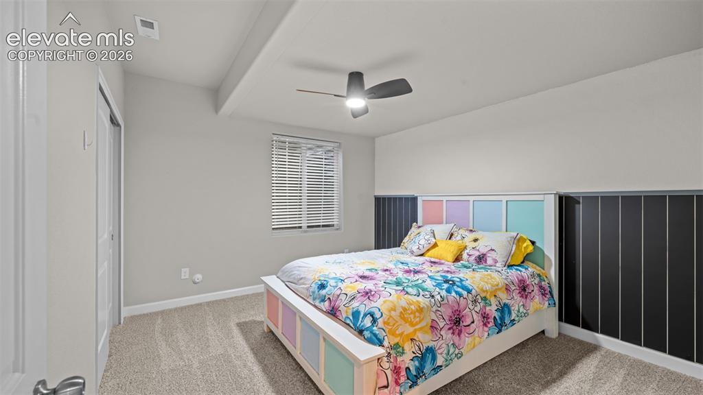 Image 26 of 39: Carpeted bedroom featuring a ceiling fan, window with blinds, and white wal