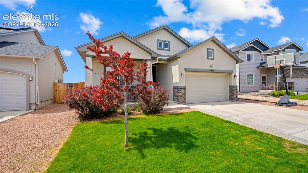 Image 3 of 39: Stucco exterior with stone accent columns, an integrated two-car garage, a