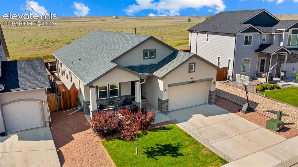 Image 31 of 39: Contemporary stucco and stone-accented exterior with a covered front porch,