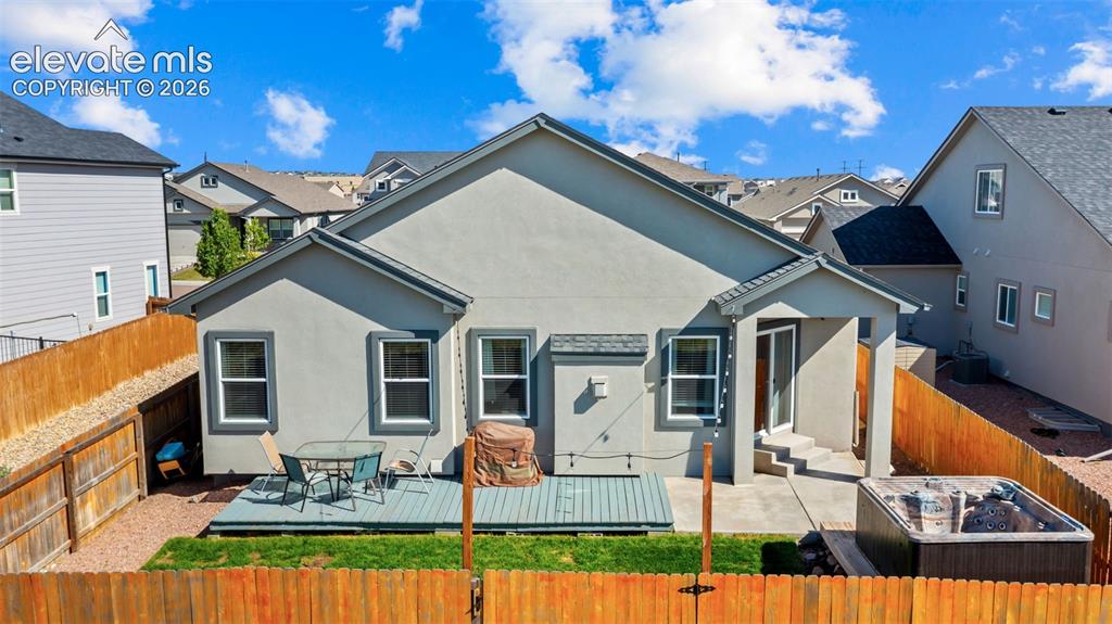 Image 35 of 39: Rear exterior featuring a multi-level deck, a concrete patio, and a built-i
