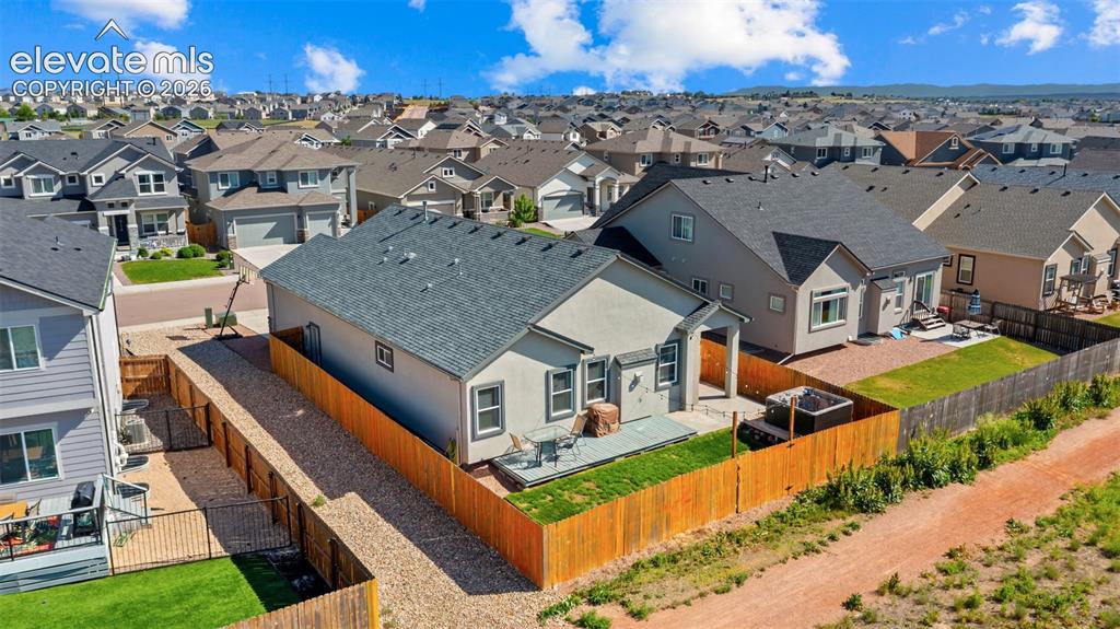 Image 37 of 39: Rear exterior of a single-story residence featuring a covered patio, a fenc