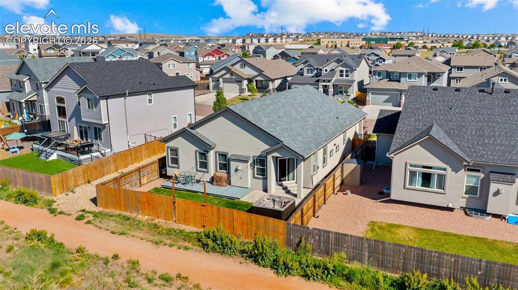 Image 39 of 39: Rear exterior featuring a patio area with a built-in fire pit, privacy fenc