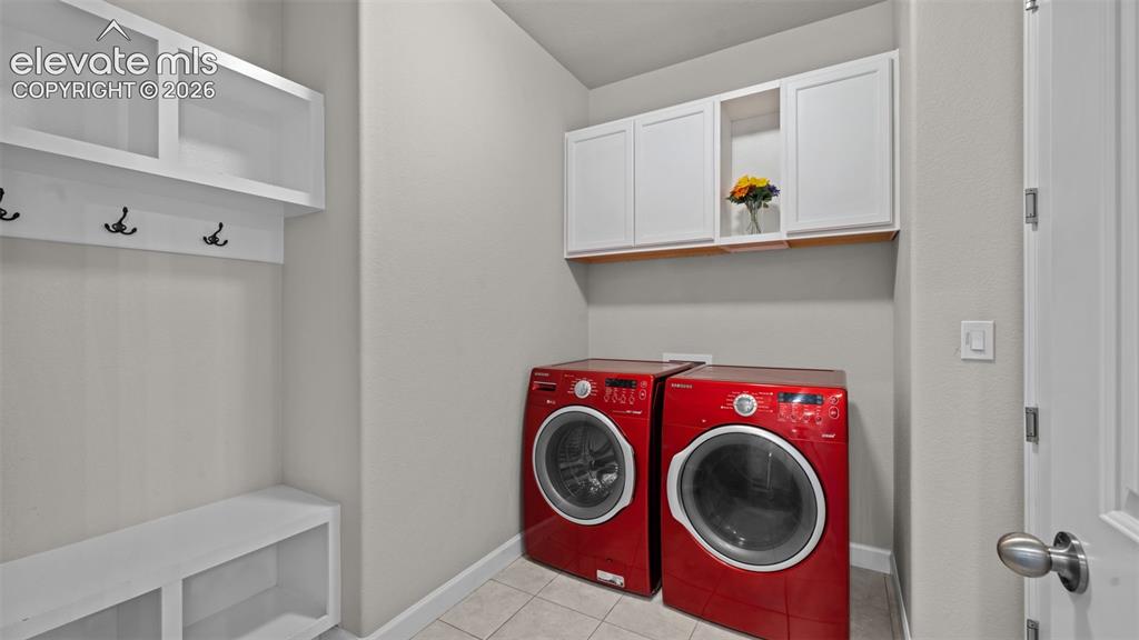 Image 7 of 39: Laundry area featuring white cabinetry, built-in shelving, and coat hooks