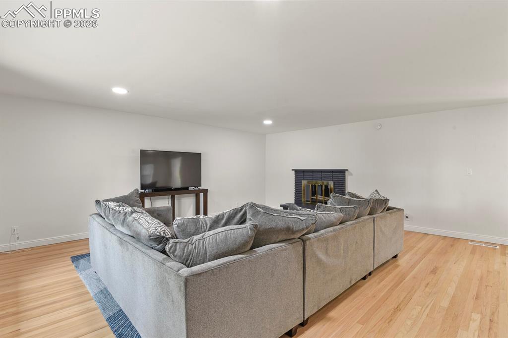 Image 21 of 48: Spacious living room featuring hardwood flooring, recessed lighting and a f