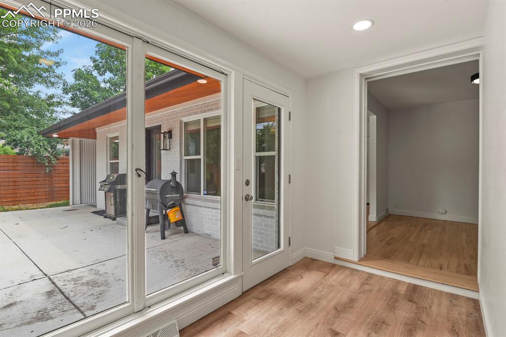 Image 24 of 48: Sunroom area with a door leading to the private back patio