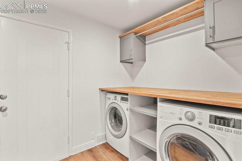 Image 29 of 48: Laundry area featuring a wood counter, cabinets and convenient clothes hang