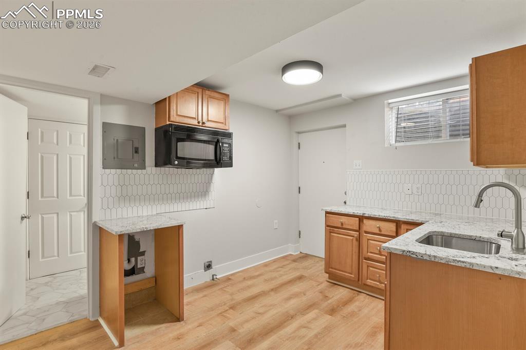Image 33 of 48: Kitchenette in basement featuring LVP flooring, microwave, sink, dishwasher