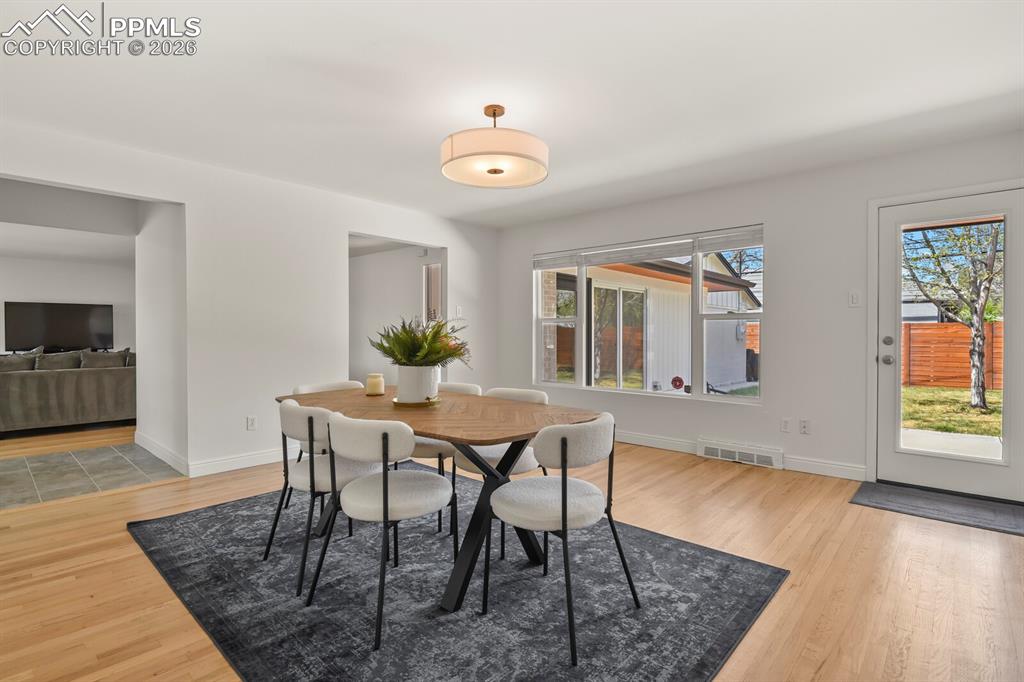 Image 6 of 48: Dining area featuring hardwood flooring, ample natural light through a larg