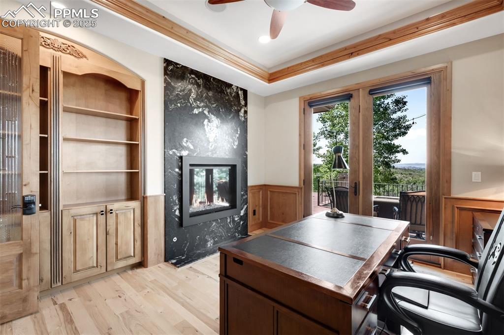 Image 17 of 47: Ample built-in bookshelves, wood paneled wainscotting & a leathered granite