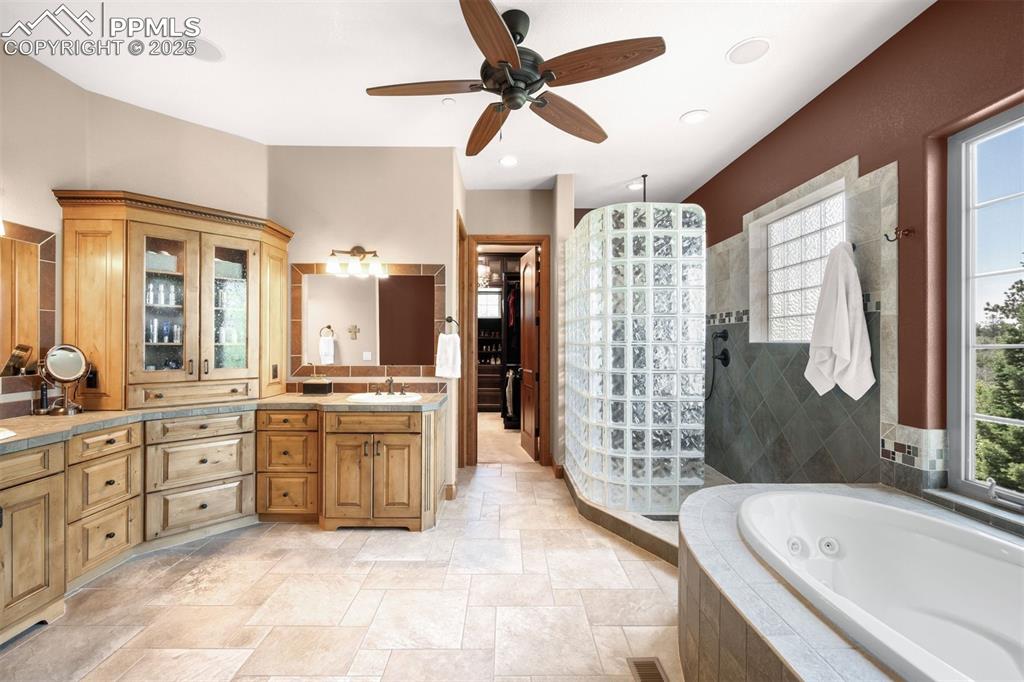 Image 21 of 47: Primary bath is resplendent with fireplace, jetted soaking tub with amazing