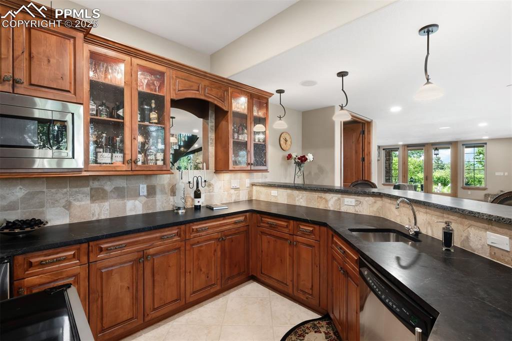 Image 28 of 47: Step behind the soapstone bar to find a kitchenette complete with dishwashe