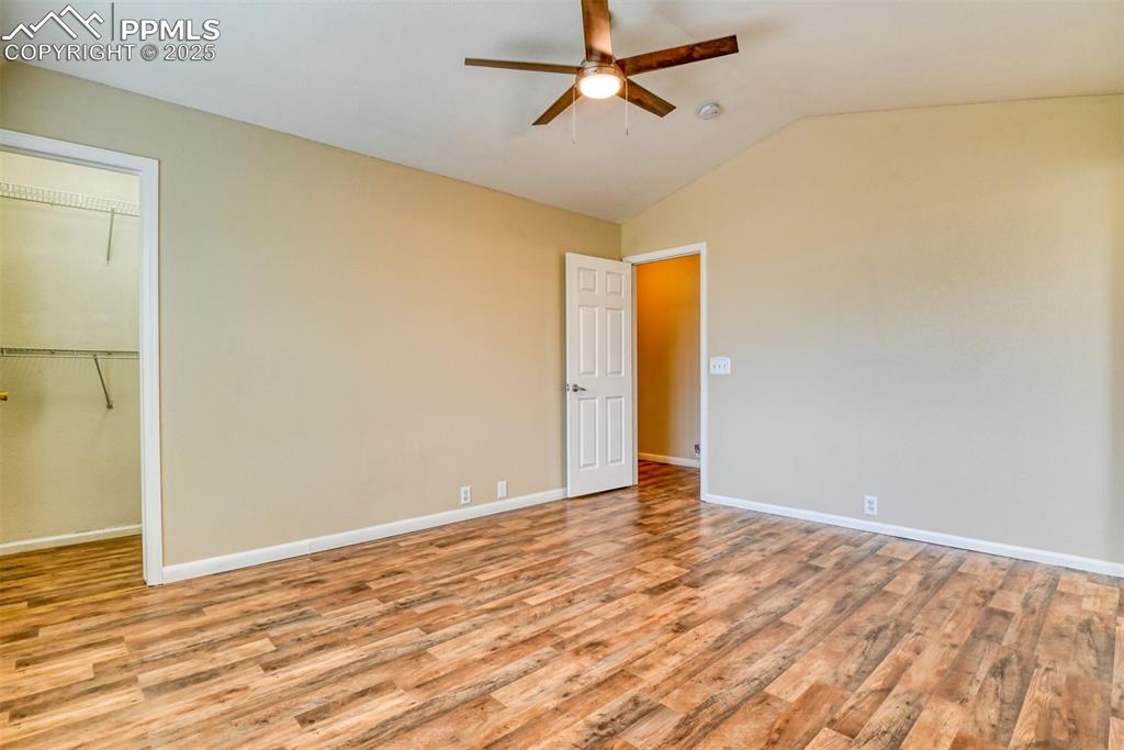 Image 11 of 21: Unfurnished bedroom featuring light wood finished floors, vaulted ceiling, 