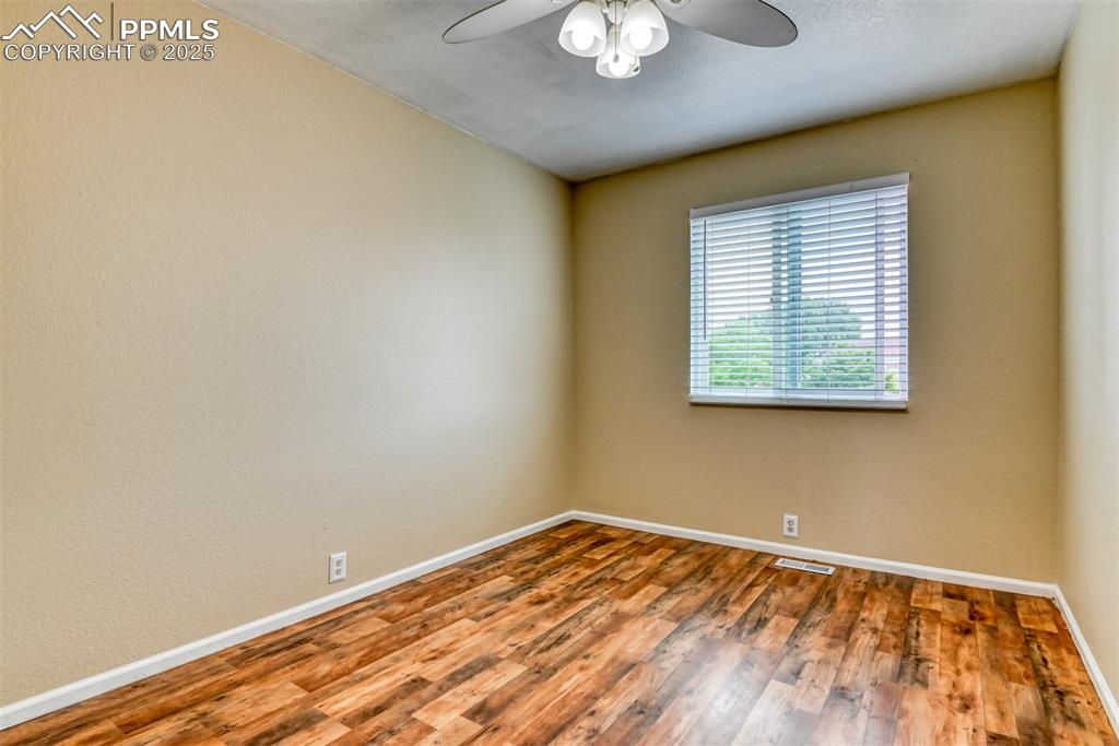 Image 13 of 21: Unfurnished room with a ceiling fan and wood finished floors