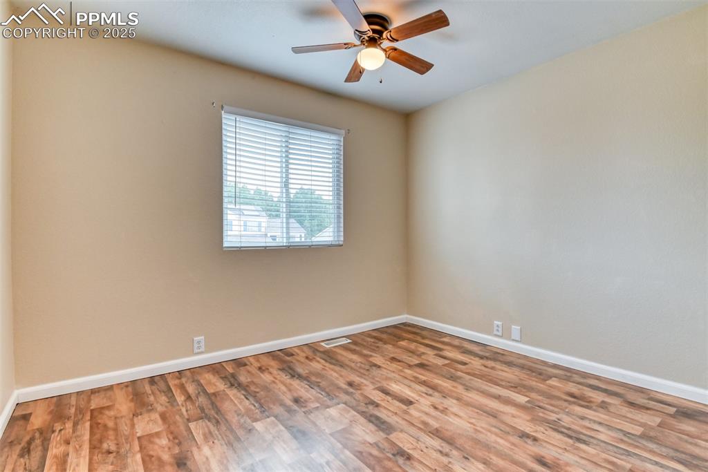 Image 15 of 21: Spare room featuring wood finished floors and ceiling fan