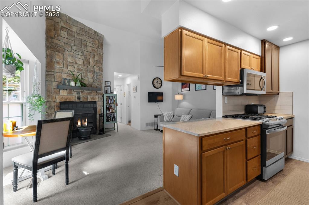 Image 4 of 26: Kitchen featuring appliances with stainless steel finishes, wood cabinetry,