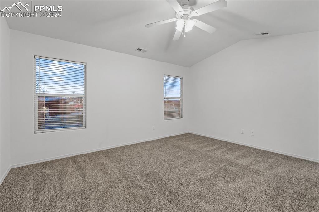 Image 12 of 20: Bedroom featuring lofted ceiling, light colored carpet, and ceiling fan