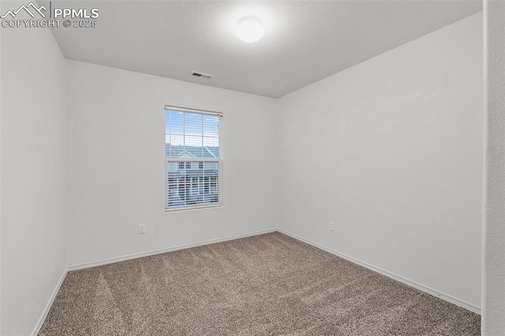 Image 15 of 20: Unfurnished room featuring carpet and a textured ceiling
