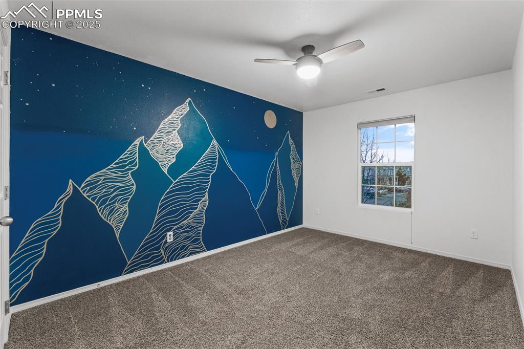 Image 16 of 20: Carpeted spare room featuring an accent wall and ceiling fan
