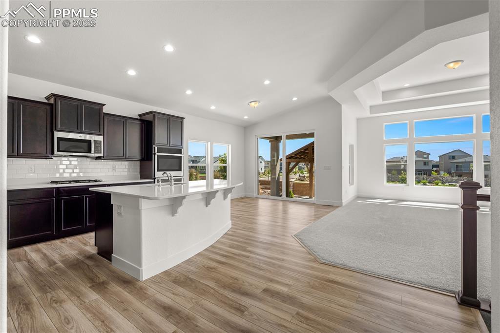 Image 12 of 46: Kitchen featuring backsplash, recessed lighting, a center island with sink,