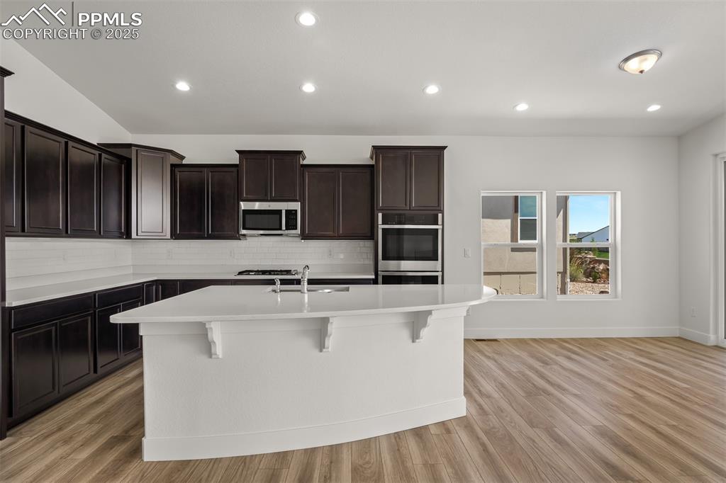 Image 13 of 46: Kitchen with backsplash, recessed lighting, light countertops, a breakfast