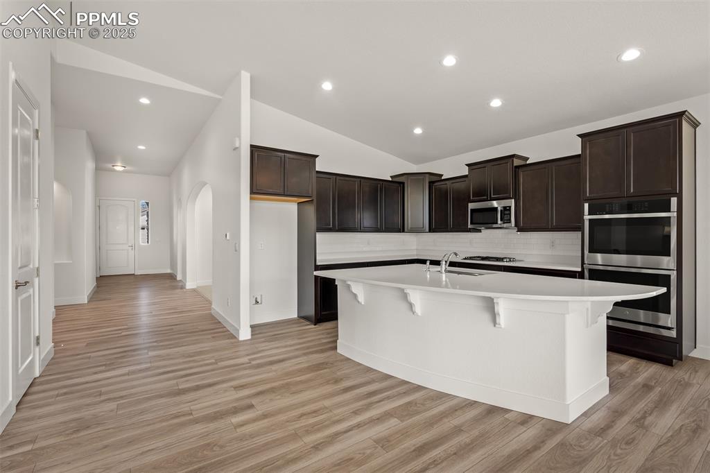 Image 14 of 46: Kitchen featuring lofted ceiling, recessed lighting, light countertops, a k