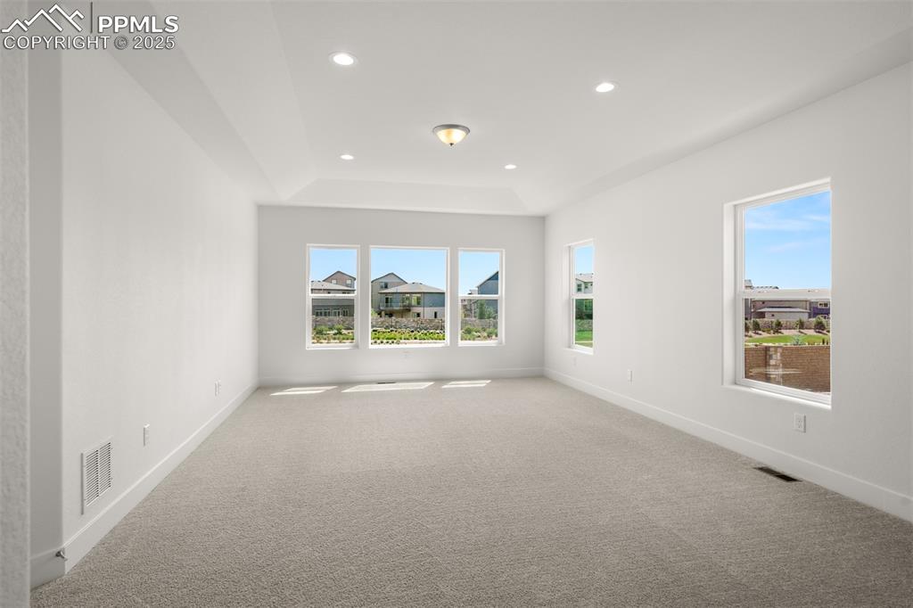 Image 25 of 46: Unfurnished room with light carpet, a tray ceiling, and recessed lighting