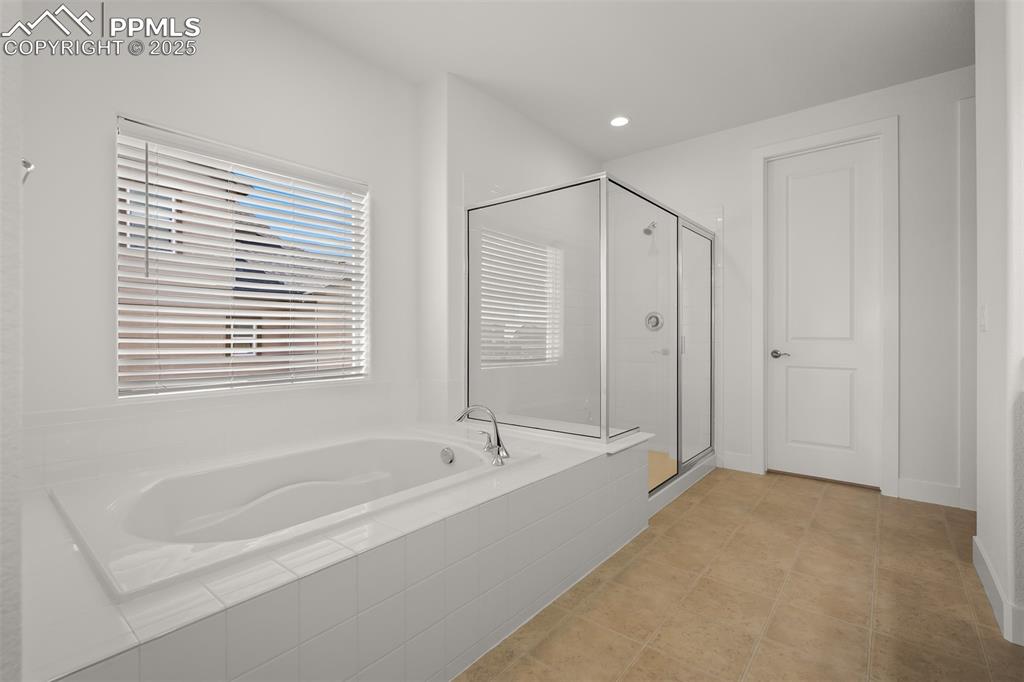 Image 29 of 46: Bathroom featuring a garden tub, a shower stall, and recessed lighting