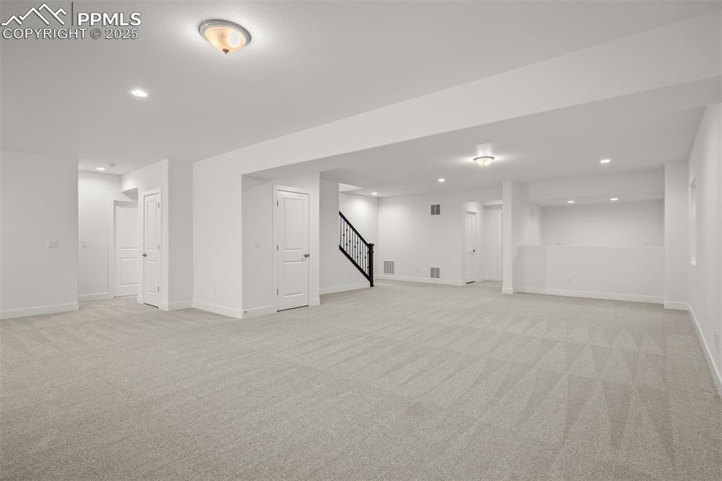 Image 38 of 46: Finished basement featuring recessed lighting, light colored carpet, and st