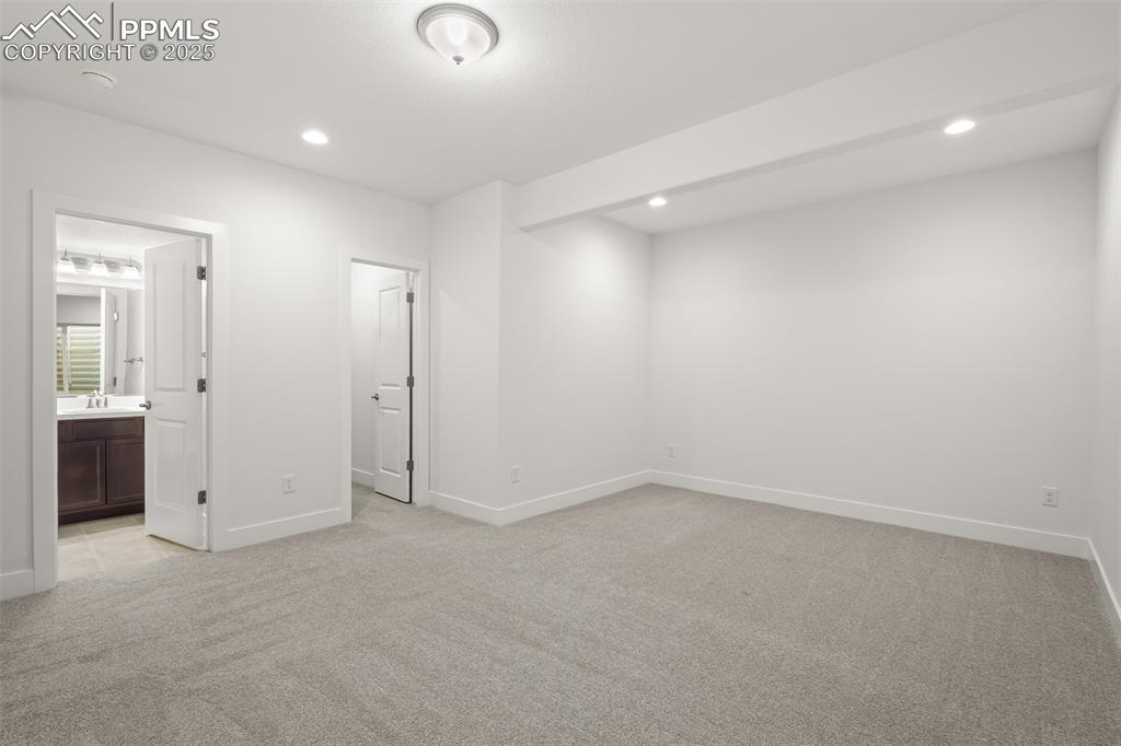 Image 40 of 46: Unfurnished bedroom with light carpet, recessed lighting, and ensuite bathr