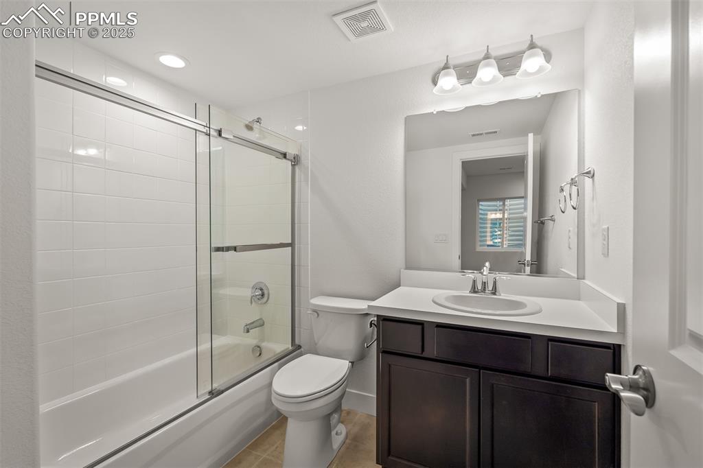 Image 41 of 46: Bathroom with vanity and enclosed tub / shower combo